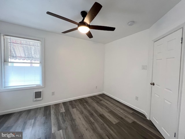 empty room with ceiling fan and dark hardwood / wood-style flooring