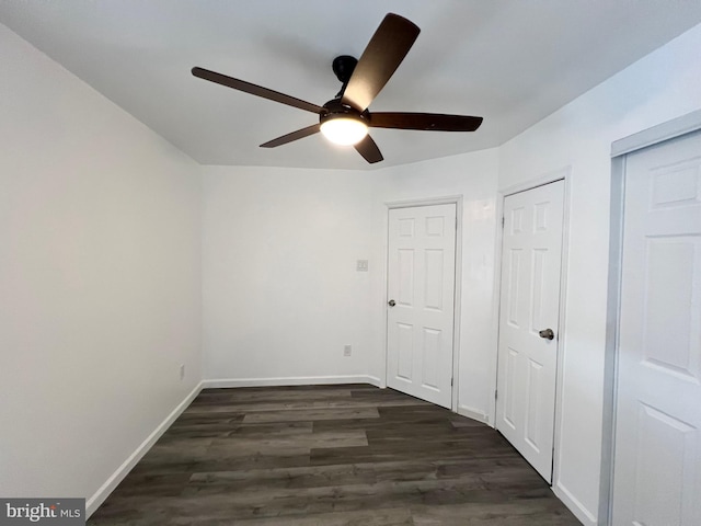 unfurnished bedroom with ceiling fan and dark hardwood / wood-style floors