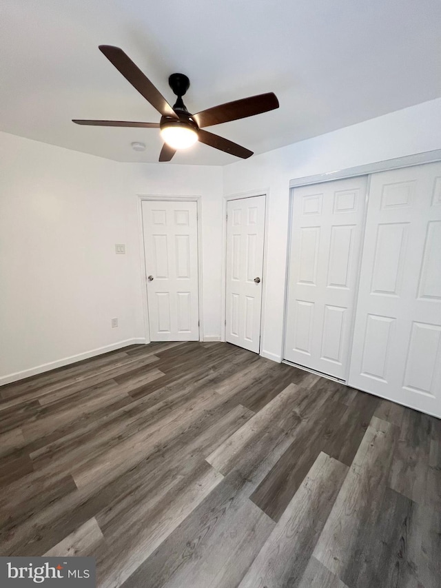 unfurnished bedroom with ceiling fan and dark hardwood / wood-style floors