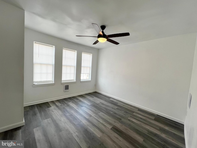 empty room with ceiling fan and dark hardwood / wood-style floors