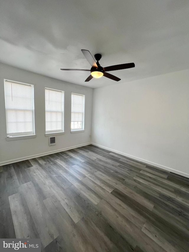 empty room featuring dark wood-type flooring and ceiling fan