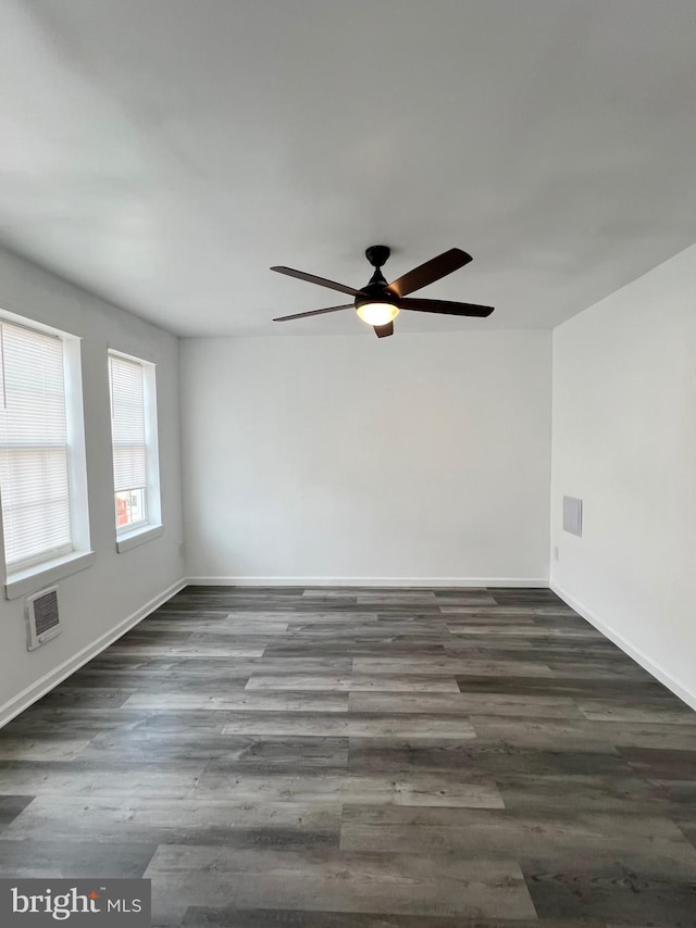 unfurnished room featuring dark wood-type flooring and ceiling fan