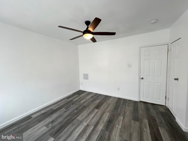 empty room with ceiling fan and dark hardwood / wood-style flooring