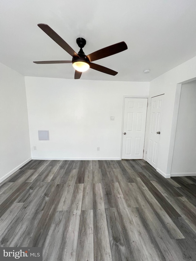 spare room with dark wood-type flooring and ceiling fan