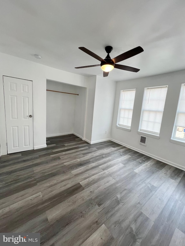 unfurnished bedroom with ceiling fan and dark hardwood / wood-style flooring