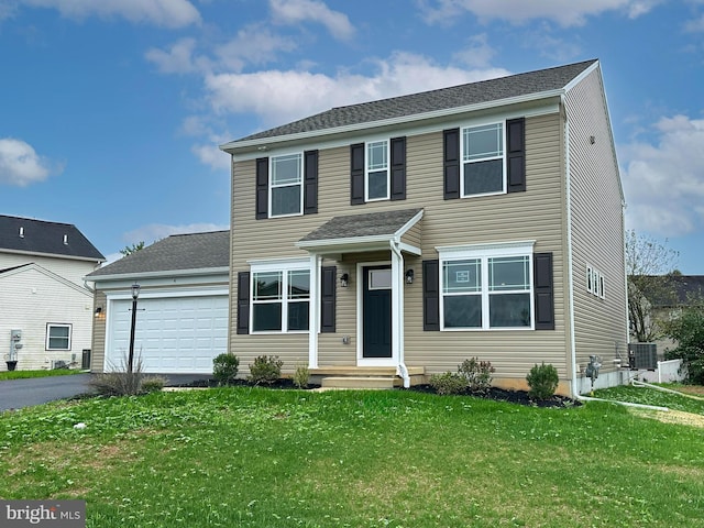 view of front of home with a front yard, a garage, and cooling unit