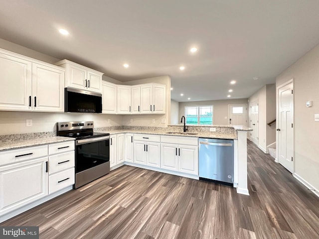 kitchen featuring kitchen peninsula, sink, stainless steel appliances, and white cabinetry