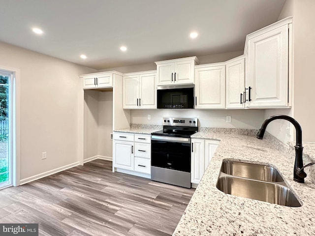 kitchen with white cabinetry, stainless steel electric range oven, wood-type flooring, light stone countertops, and sink