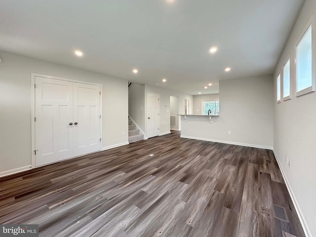 unfurnished living room with dark wood-type flooring