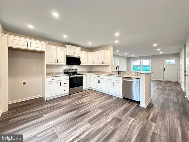 kitchen with sink, white cabinets, appliances with stainless steel finishes, and kitchen peninsula