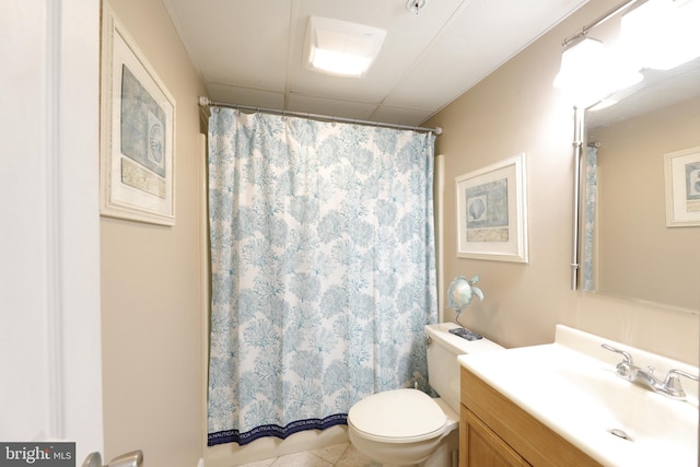 bathroom featuring tile patterned floors, toilet, vanity, and walk in shower