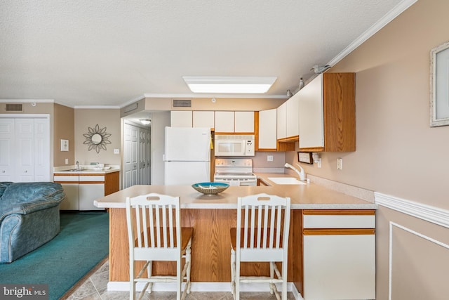 kitchen featuring kitchen peninsula, a kitchen bar, sink, and white appliances