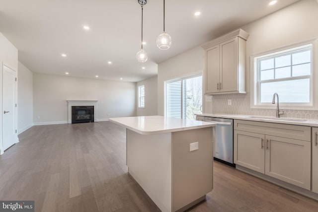 kitchen featuring white cabinetry, decorative backsplash, dishwasher, a kitchen island, and sink