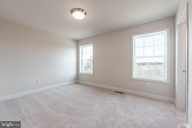 spare room featuring light colored carpet