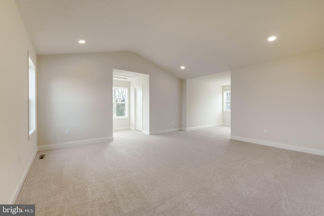 unfurnished room with light carpet and lofted ceiling