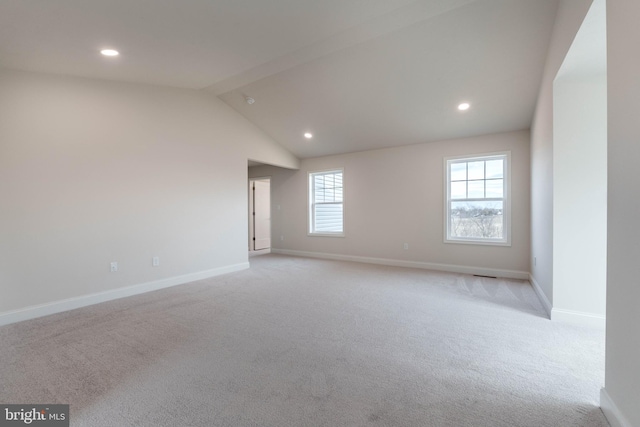 unfurnished room featuring light carpet and vaulted ceiling with beams