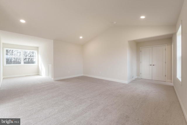 carpeted empty room with vaulted ceiling