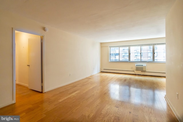 unfurnished living room featuring a baseboard radiator and light hardwood / wood-style flooring