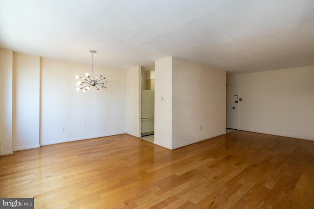 unfurnished room featuring hardwood / wood-style flooring and a notable chandelier