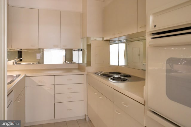 kitchen featuring white cabinets, cooktop, oven, and sink