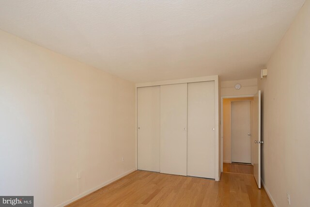 unfurnished bedroom with a closet and light hardwood / wood-style floors