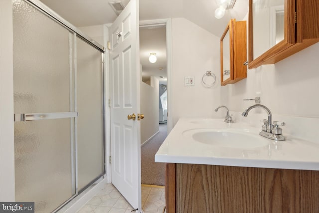 bathroom featuring a shower with door, vanity, and tile patterned flooring