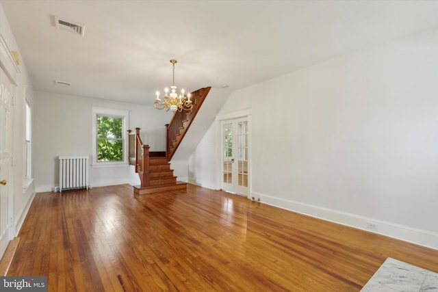 interior space featuring radiator, hardwood / wood-style flooring, a chandelier, and french doors