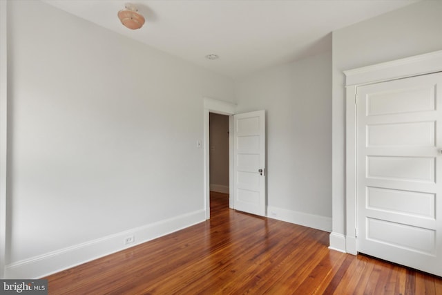 unfurnished bedroom with dark hardwood / wood-style flooring