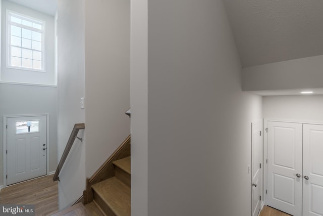 staircase featuring a high ceiling and hardwood / wood-style flooring