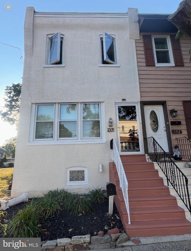 townhome / multi-family property with entry steps and stucco siding