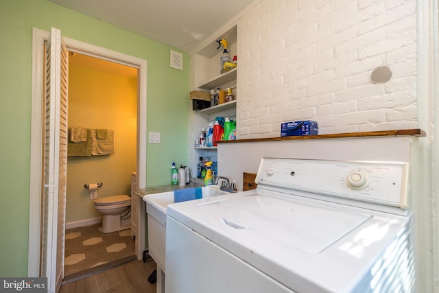 laundry room featuring a sink, washer / clothes dryer, wood finished floors, and visible vents