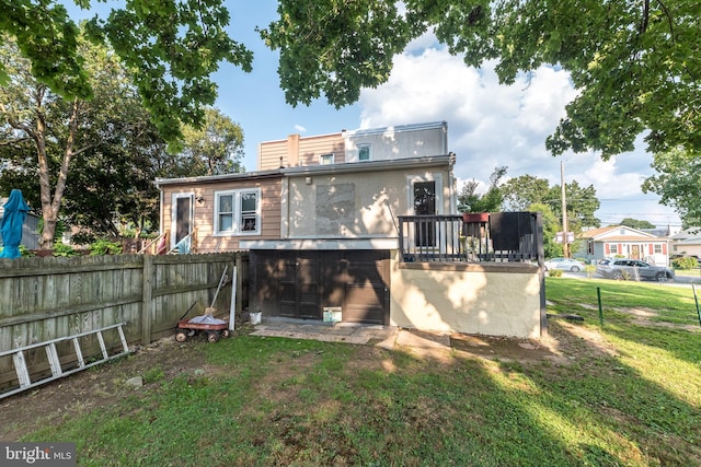 rear view of property with a deck and a yard