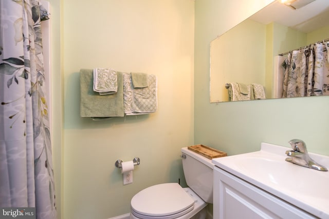 full bath with curtained shower, vanity, and toilet