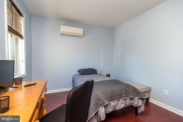 bedroom with dark wood-style floors, a wall mounted AC, and baseboards