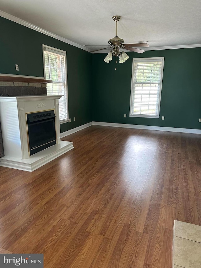 unfurnished living room with ceiling fan, wood-type flooring, ornamental molding, and a textured ceiling