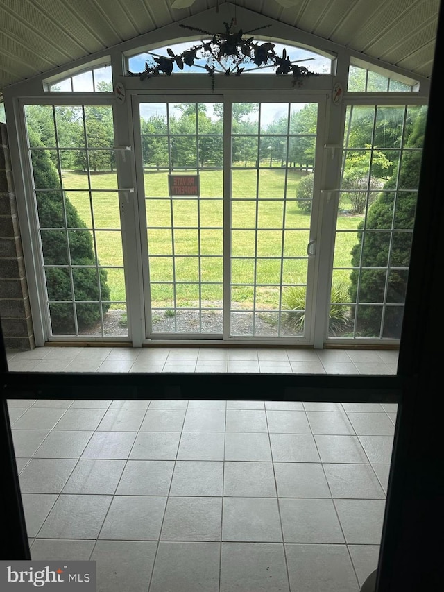 doorway to outside featuring vaulted ceiling