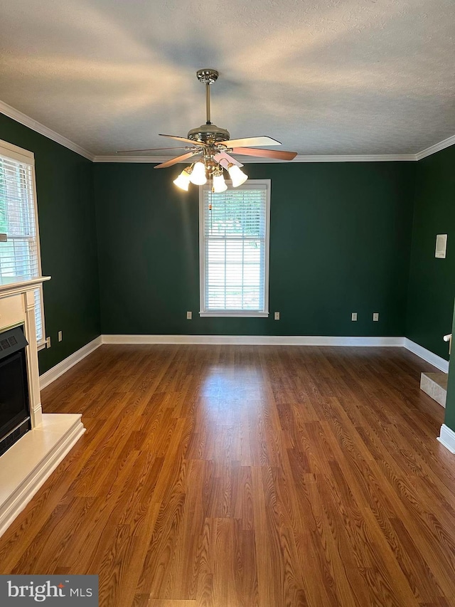 unfurnished living room with ceiling fan, hardwood / wood-style floors, crown molding, and a textured ceiling