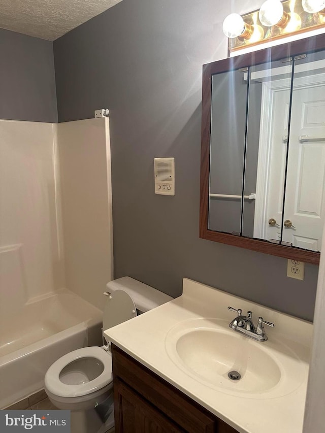 full bathroom with a textured ceiling, tile patterned flooring, vanity, shower / washtub combination, and toilet