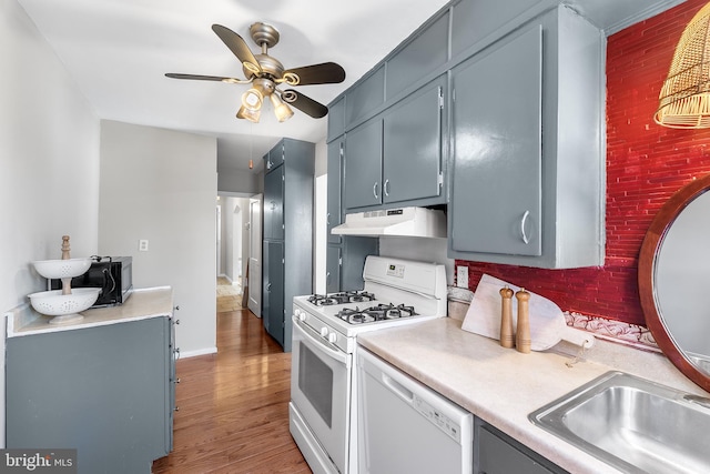 kitchen featuring decorative backsplash, dark hardwood / wood-style floors, white appliances, and ceiling fan