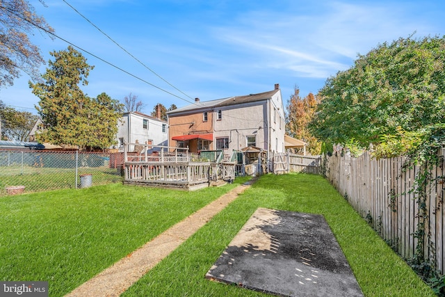 rear view of property featuring a lawn, a patio, and a deck