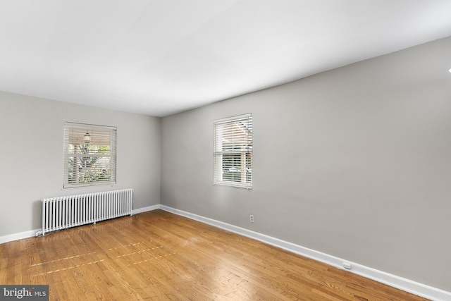 empty room featuring radiator and light wood-type flooring