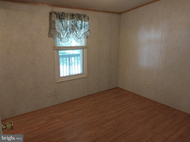 unfurnished room featuring crown molding and wood-type flooring