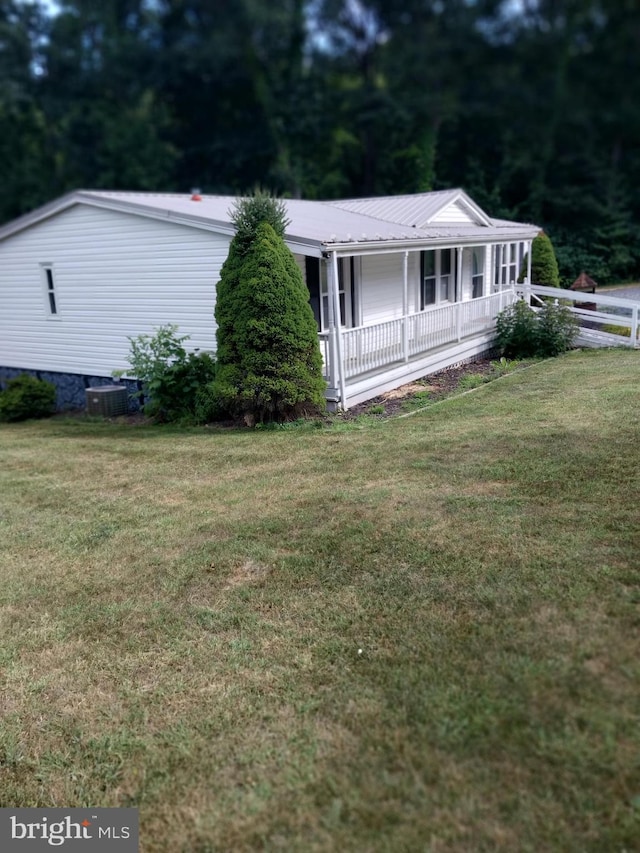 view of front facade featuring a front yard, a porch, and central air condition unit