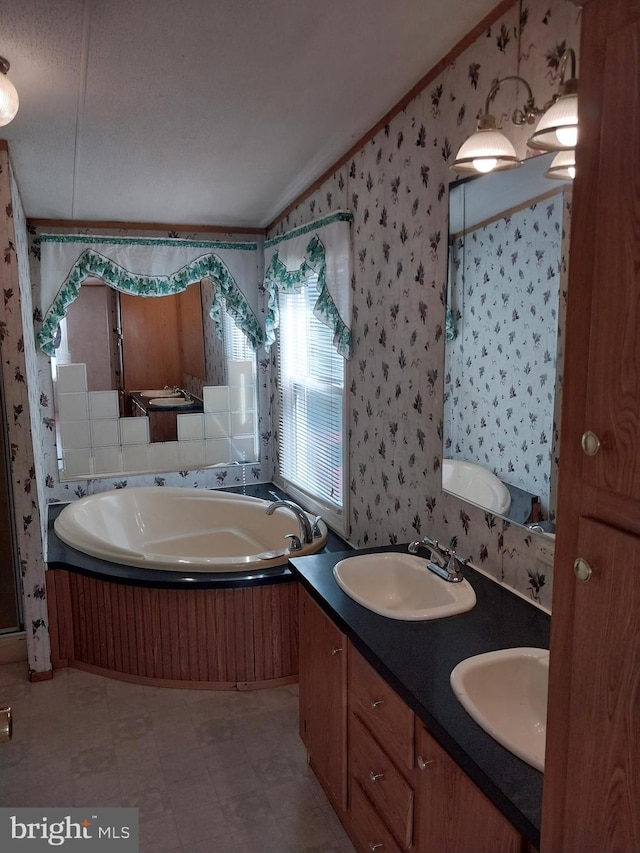 bathroom featuring vanity, a tub to relax in, ornamental molding, and a textured ceiling