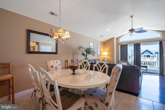 dining space featuring light tile patterned flooring, ceiling fan with notable chandelier, and vaulted ceiling