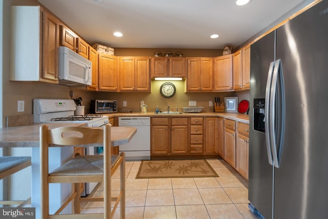 kitchen with light tile patterned flooring, sink, and white appliances