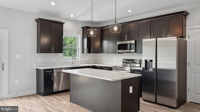 kitchen featuring pendant lighting, sink, appliances with stainless steel finishes, a center island, and dark brown cabinetry