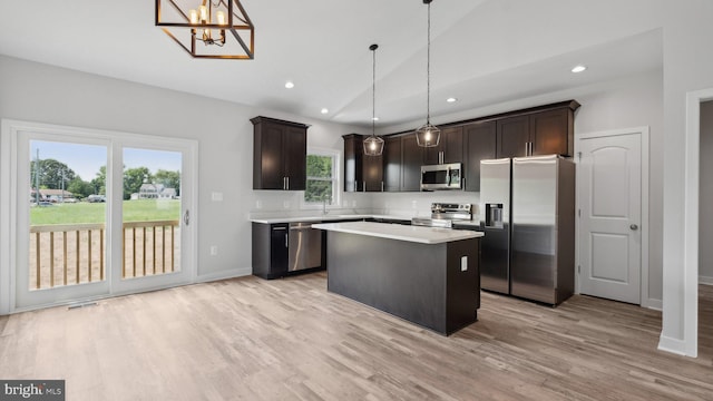 kitchen featuring pendant lighting, sink, appliances with stainless steel finishes, a center island, and dark brown cabinetry