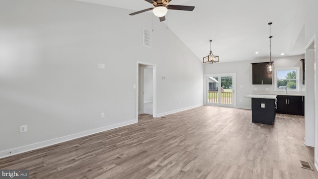 unfurnished living room featuring sink, high vaulted ceiling, ceiling fan, and light wood-type flooring