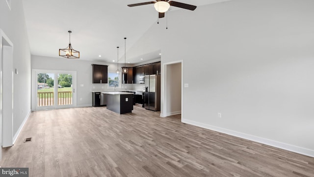 kitchen featuring hanging light fixtures, a center island, stainless steel refrigerator with ice dispenser, dark brown cabinets, and light hardwood / wood-style flooring